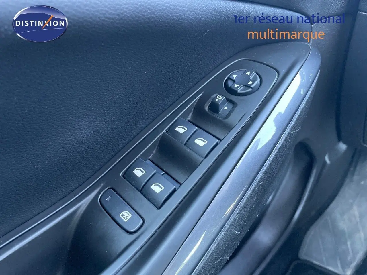 Gros plan sur la commande des vitres électriques côté conducteur d'un Opel Grandland X gris quartz metal.