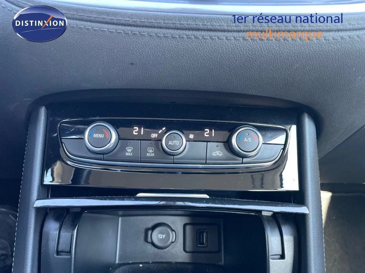 Console centrale de l'Opel Grandland X 2021 montrant les commandes de climatisation et prise 12V en noir brillant.