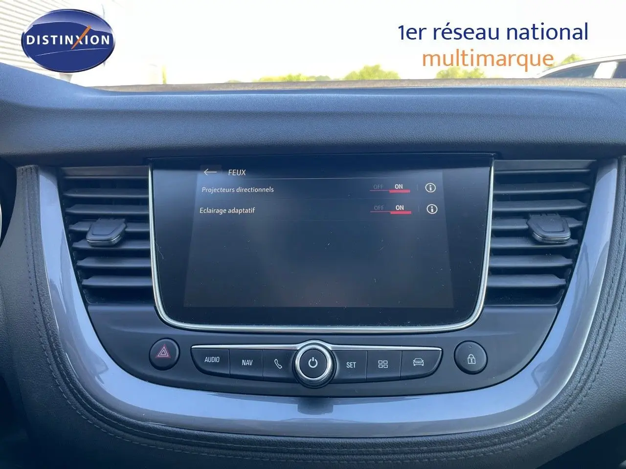 Vue rapprochée de la console centrale de l’Opel Grandland X 2021, écran tactile avec réglages des feux activés.