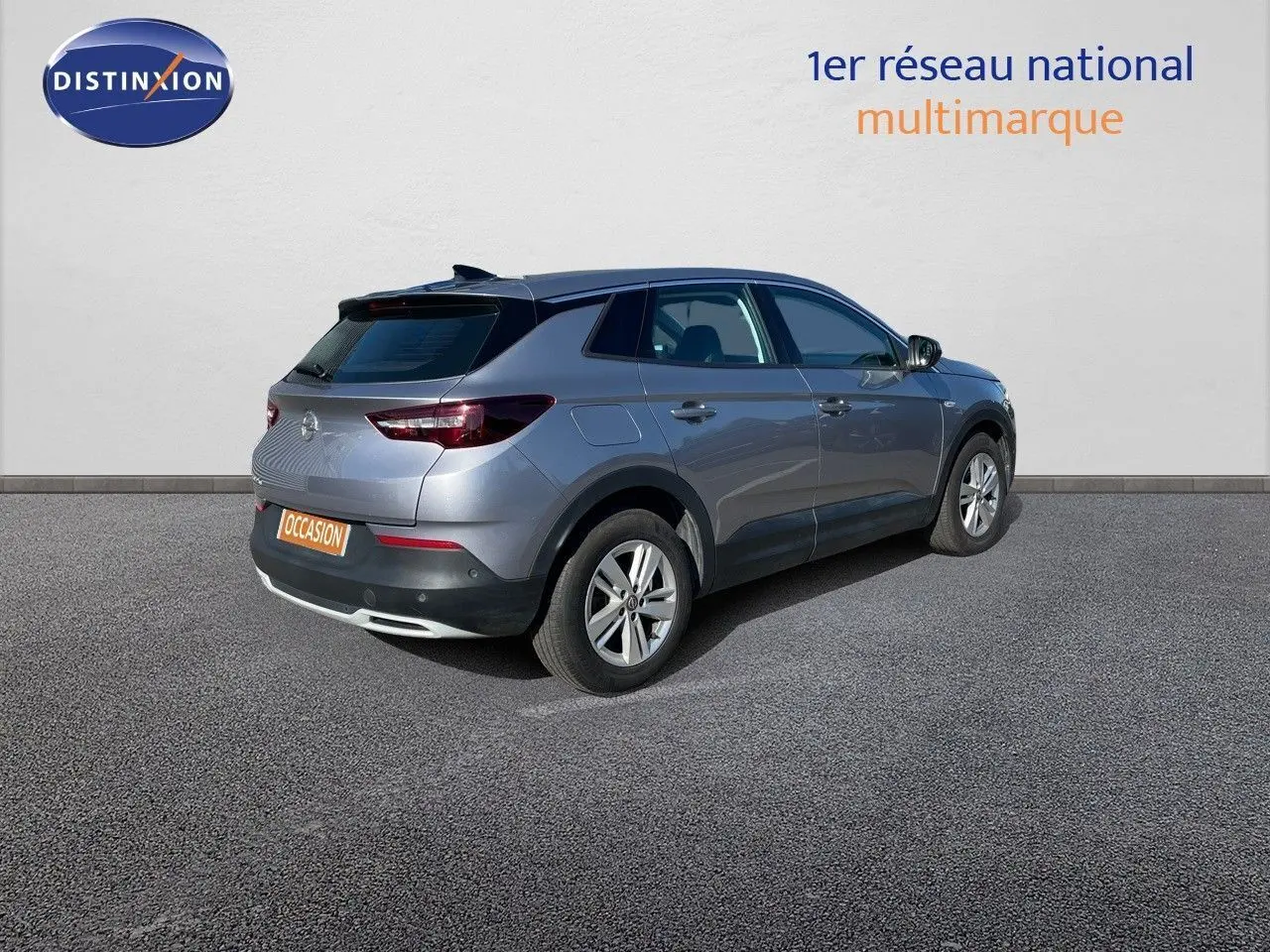 Opel Grandland X gris quartz métal vu en 3/4 arrière côté droit sur fond neutre avec plaque occasion.