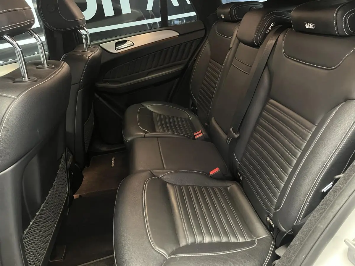 Vue intérieure de la banquette arrière en cuir noir du Mercedes GLE Coupé 350 d Sportline blanc, avec appuie-têtes AMG.