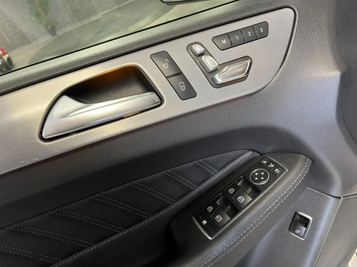 Détail de la porte intérieure côté conducteur du Mercedes GLE Coupé blanc, avec commandes électriques et réglages mémoire.