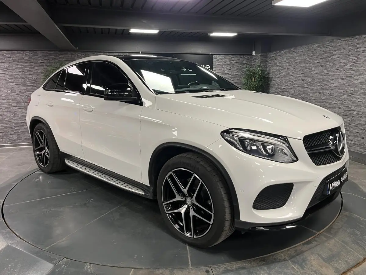Mercedes GLE Coupé blanc en 3/4 avant droit avec jantes AMG noires et coques de rétroviseurs noires brillantes