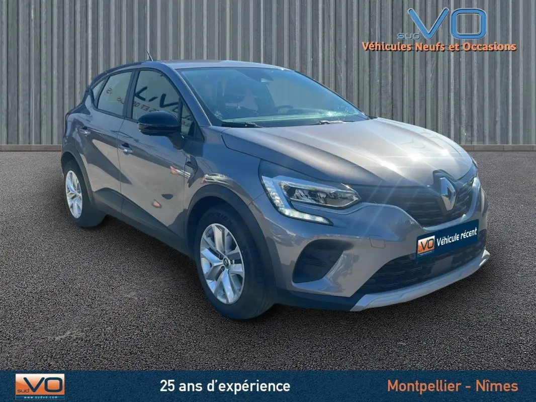 Renault Captur TCe 90 Business gris vu en 3/4 avant droit avec feux LED et jantes alliage sur fond neutre.