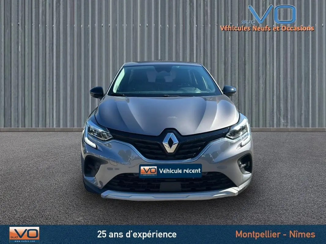 Vue frontale d'un Renault Captur gris 2021 avec feux allumés et logo marqué sur la calandre.