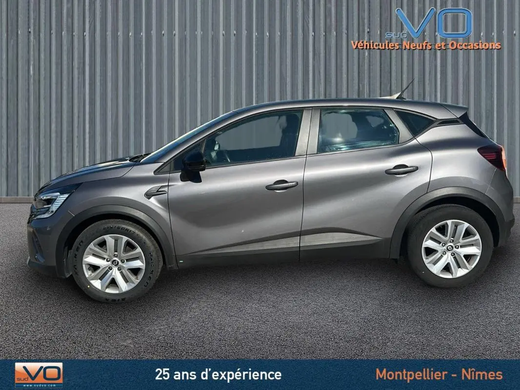 Profil côté gauche d'un Renault Captur gris 2021 TCe 90 Business avec jantes alliage et vitres teintées.