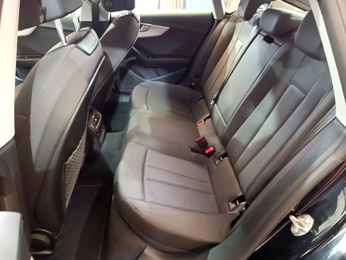 Vue côté droit de la banquette arrière noire de l'Audi A5 35 TFSI 2021 avec appuie-têtes et ceintures visibles.