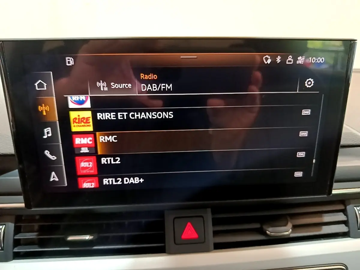Écran central tactile de l'Audi A5 35 TFSI 2021 affichant la liste des radios DAB/FM en intérieur noir.