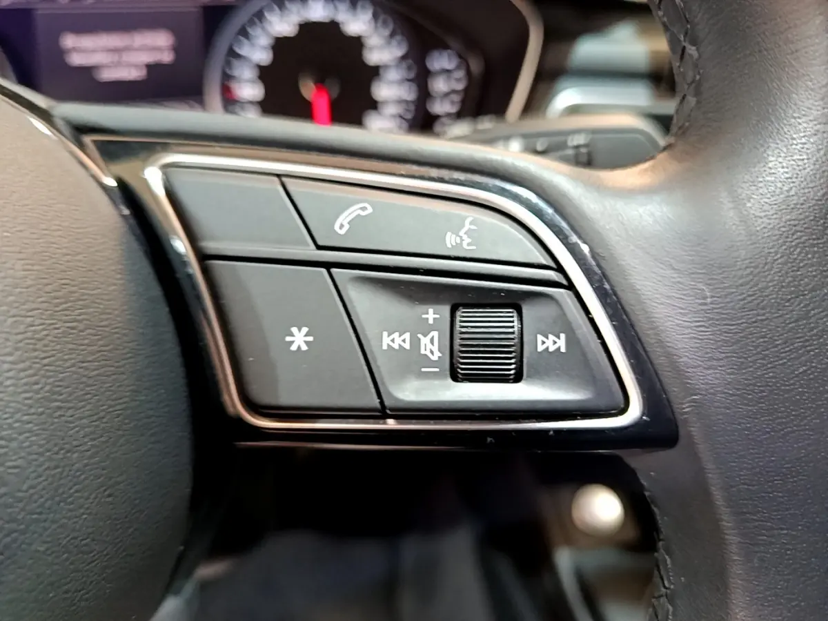 Gros plan sur les commandes audio et téléphone au volant cuir noir de l'Audi A5 35 TFSI 2021.