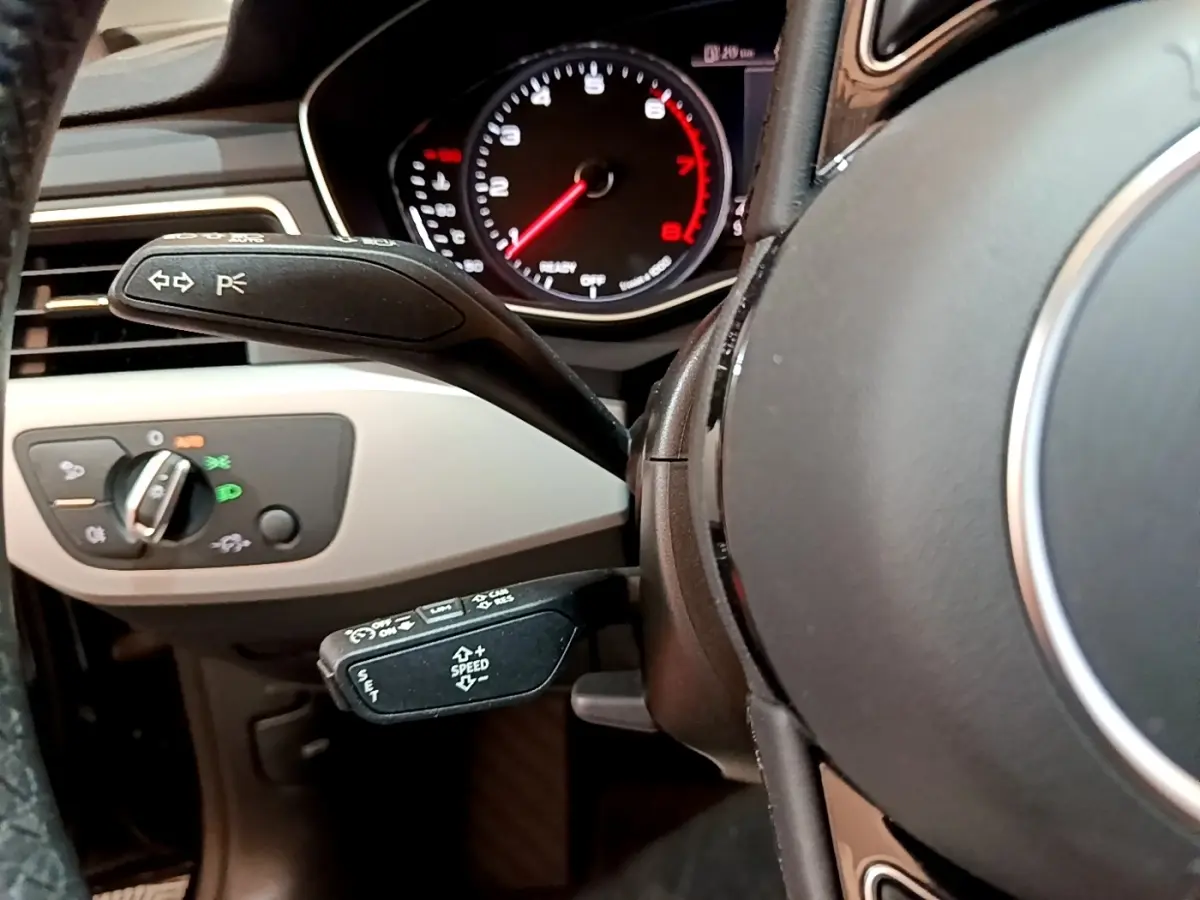 Gros plan sur le volant noir et le tableau de bord avec compte-tours rouge d'une Audi A5 35 TFSI 2021.