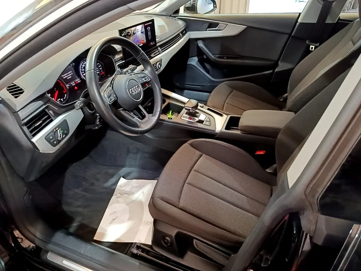 Vue intérieure côté conducteur de l'Audi A5 35 TFSI 2021 avec tableau de bord digital et sièges tissu noirs.