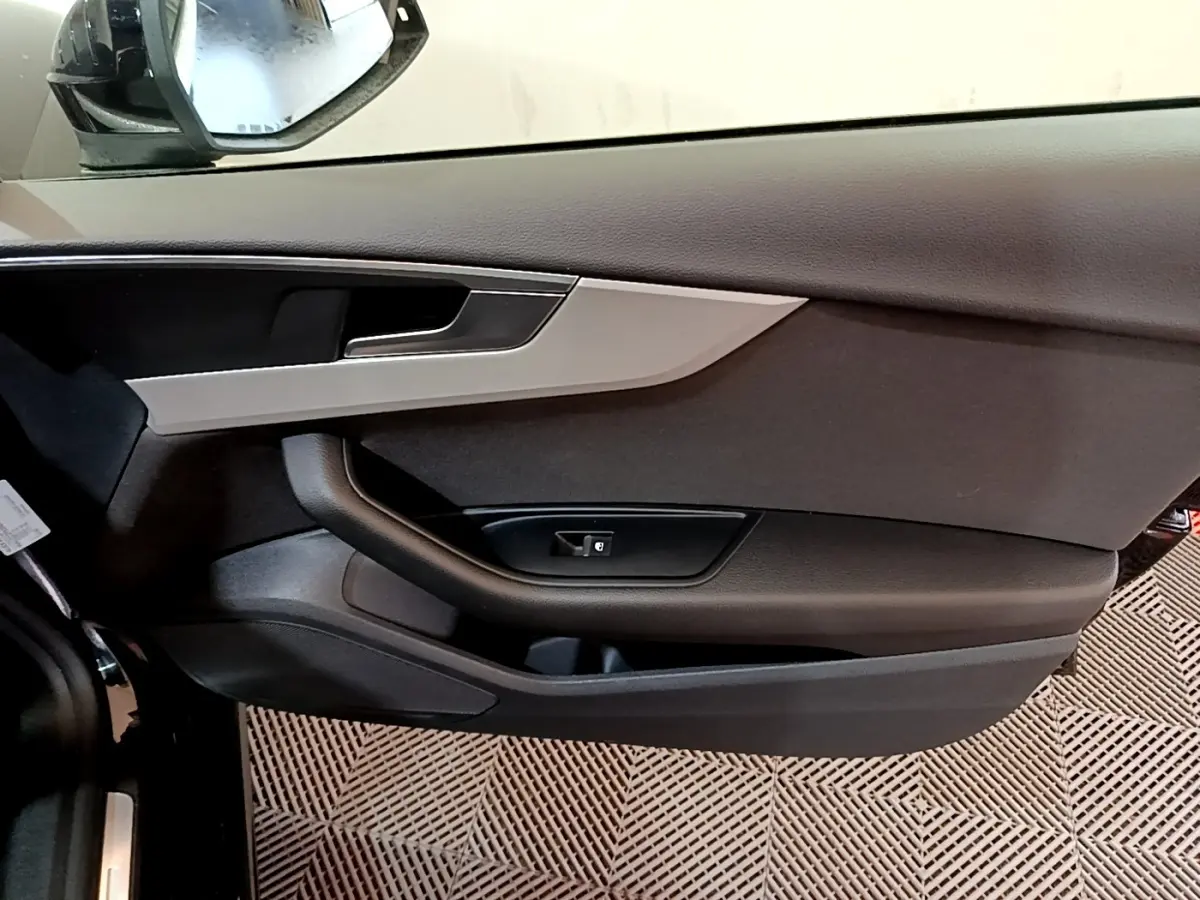 Vue rapprochée de la porte côté conducteur noire de l'Audi A5 35 TFSI 2021 avec insert argenté et poignée intégrée.