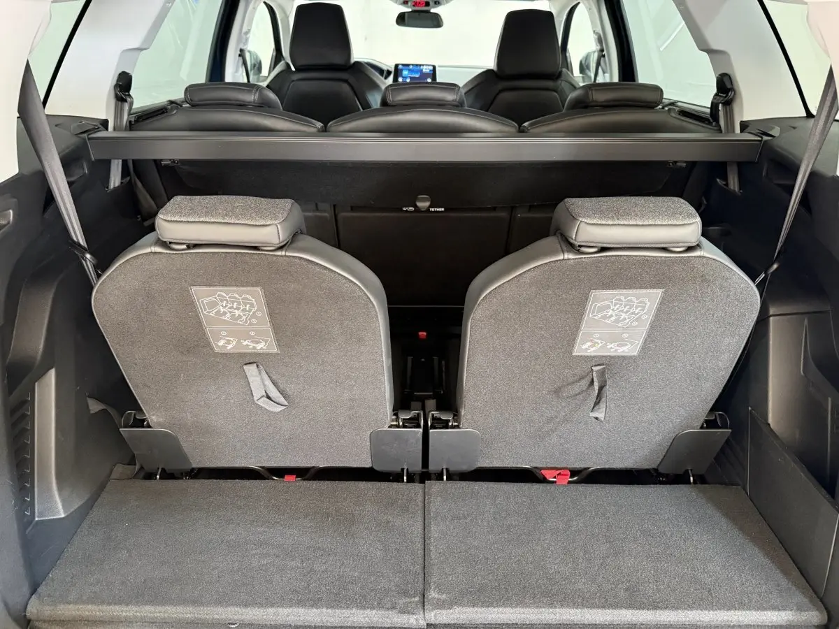 Vue arrière intérieure du coffre du Peugeot 5008 bleu, montrant les sièges arrière individuels rabattus et amovibles.