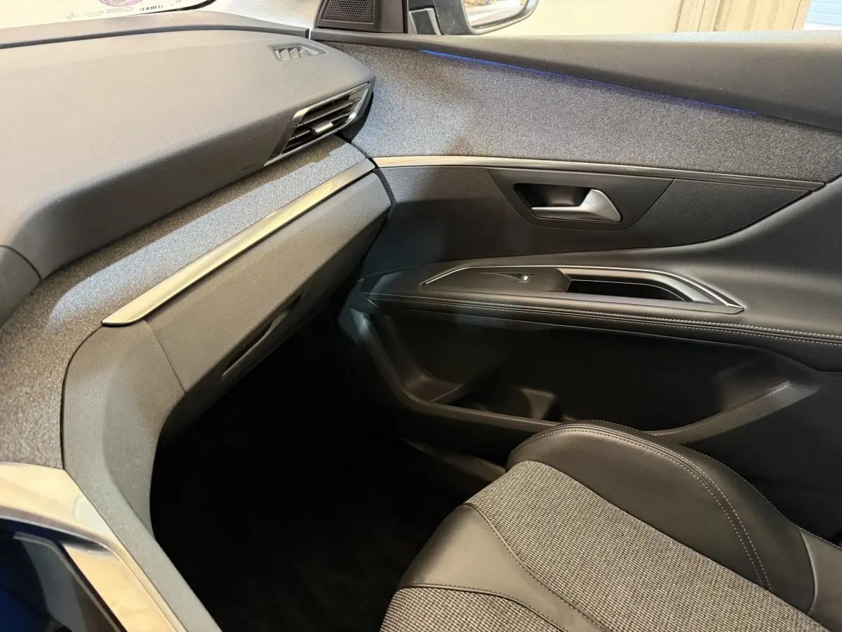 Vue intérieure côté passager avant du Peugeot 5008 2019, avec sellerie cuir noire et tableau de bord gris foncé.