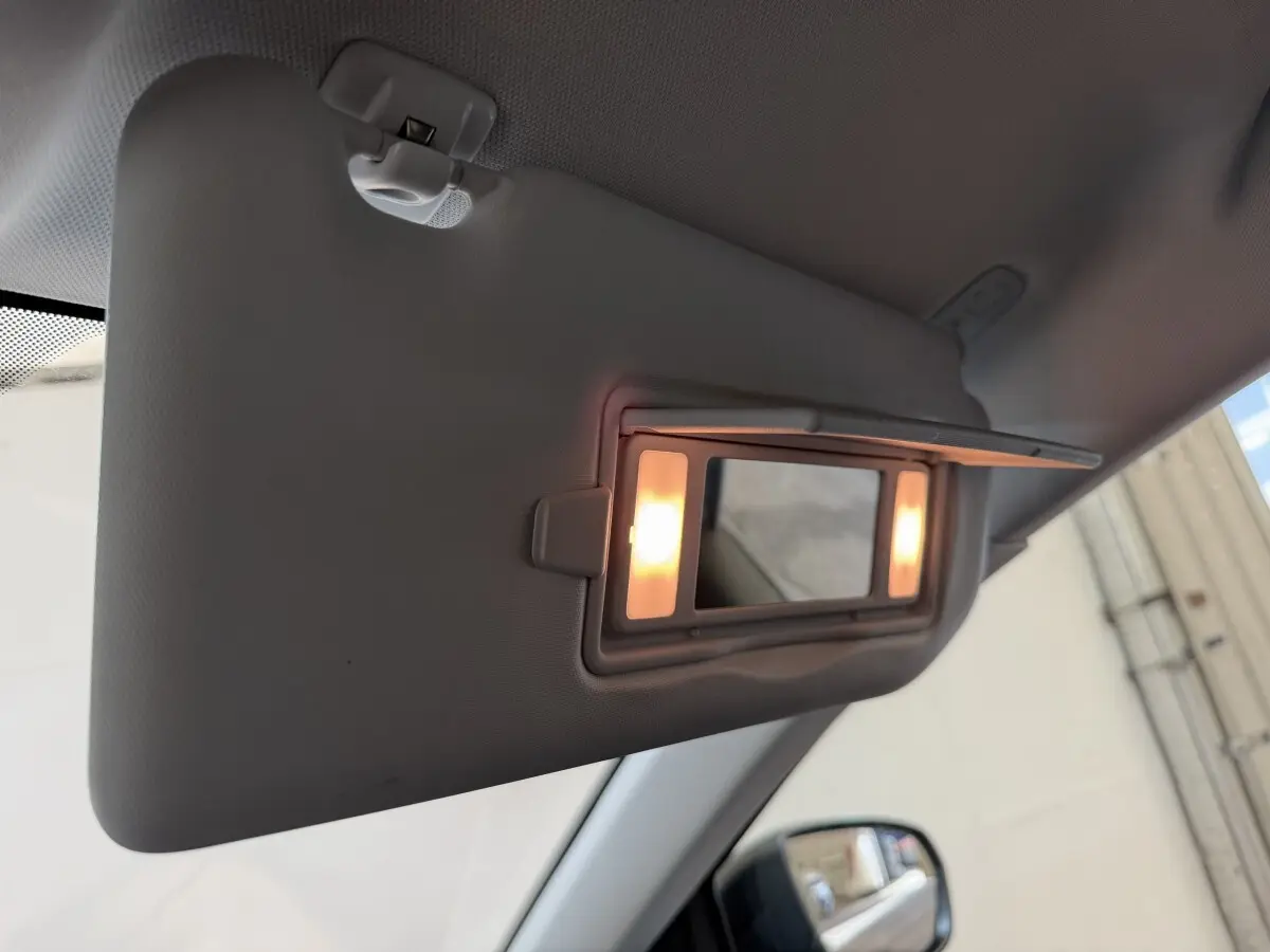 Détail du pare-soleil côté conducteur avec miroir éclairé dans l’habitacle d’un Peugeot 5008 bleu.