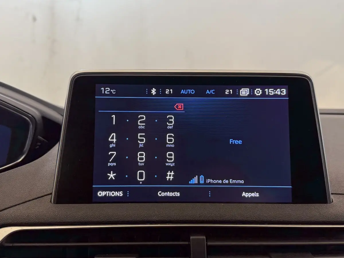 Écran tactile central du tableau de bord du Peugeot 5008 bleu, affichant le clavier téléphonique et les options de connexion.