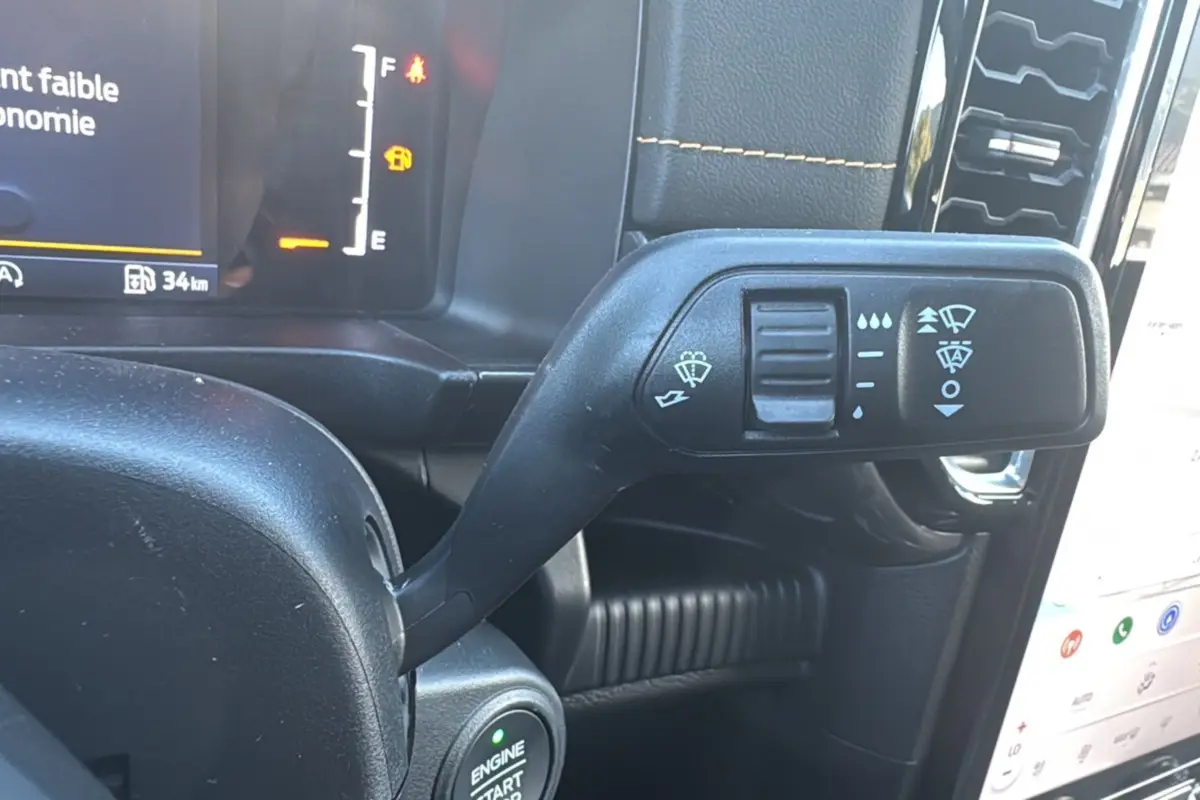 Gros plan sur la commande d’essuie-glace à gauche du volant dans l’habitacle du Ford Ranger gris carbone 2025.
