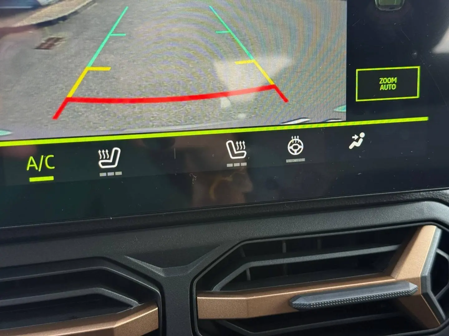 Vue rapprochée de l'écran tactile et des aérateurs intérieurs couleur bronze du Dacia Duster blanc 2026.