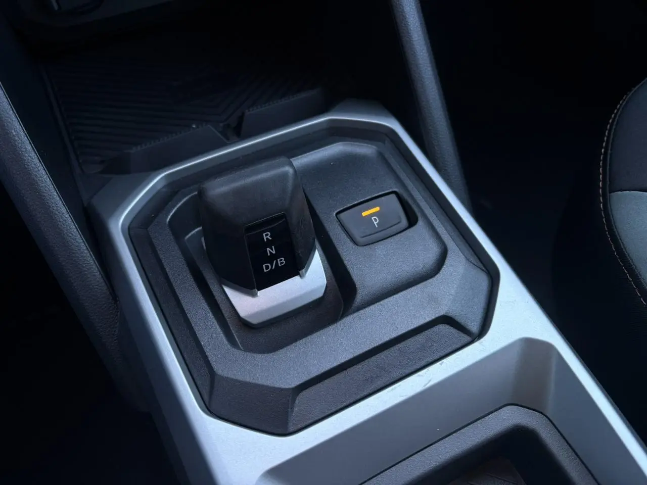 Gros plan sur la console centrale du Dacia Duster 2026, montrant le levier de boîte auto et le bouton de parking.