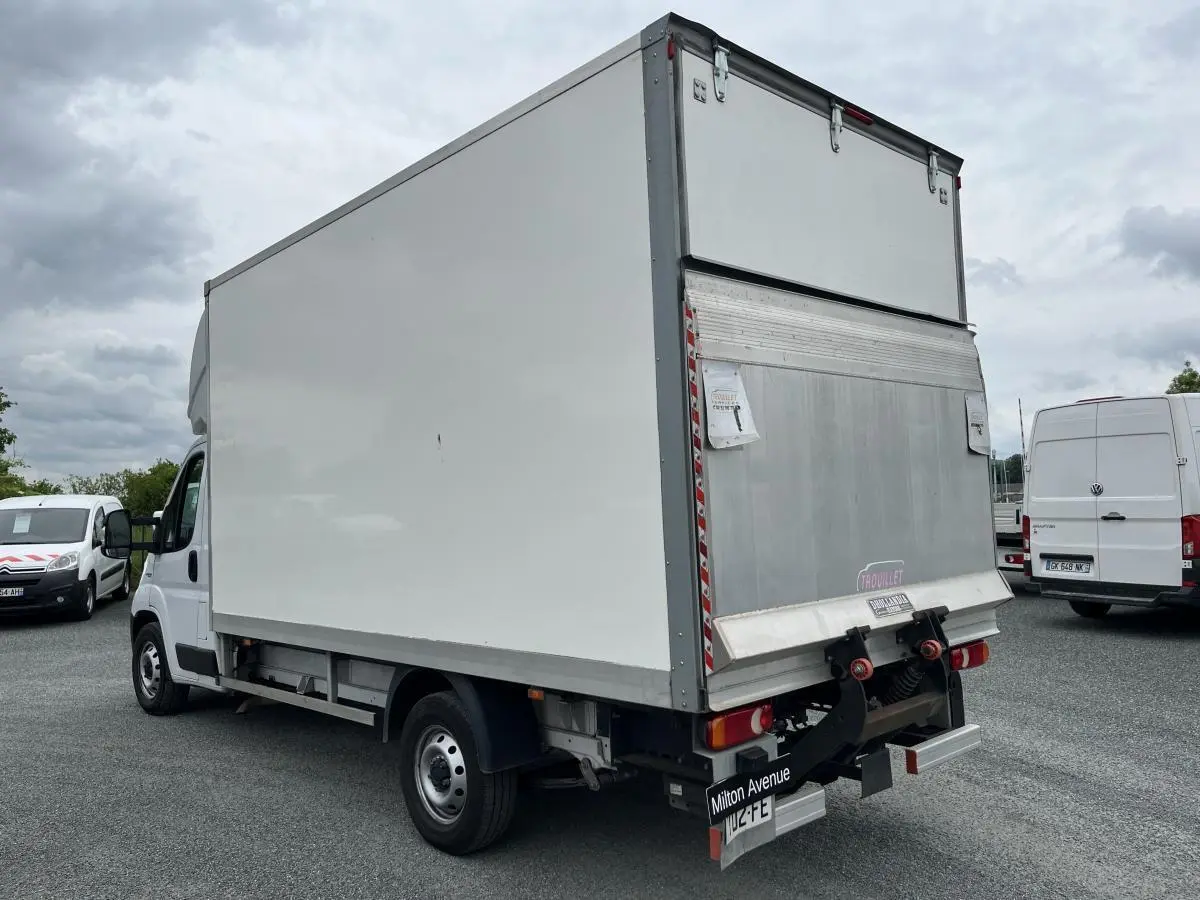 FIAT Ducato Fourgon blanc vu en 3/4 arrière droit avec grande caisse de chargement fermée en métal.