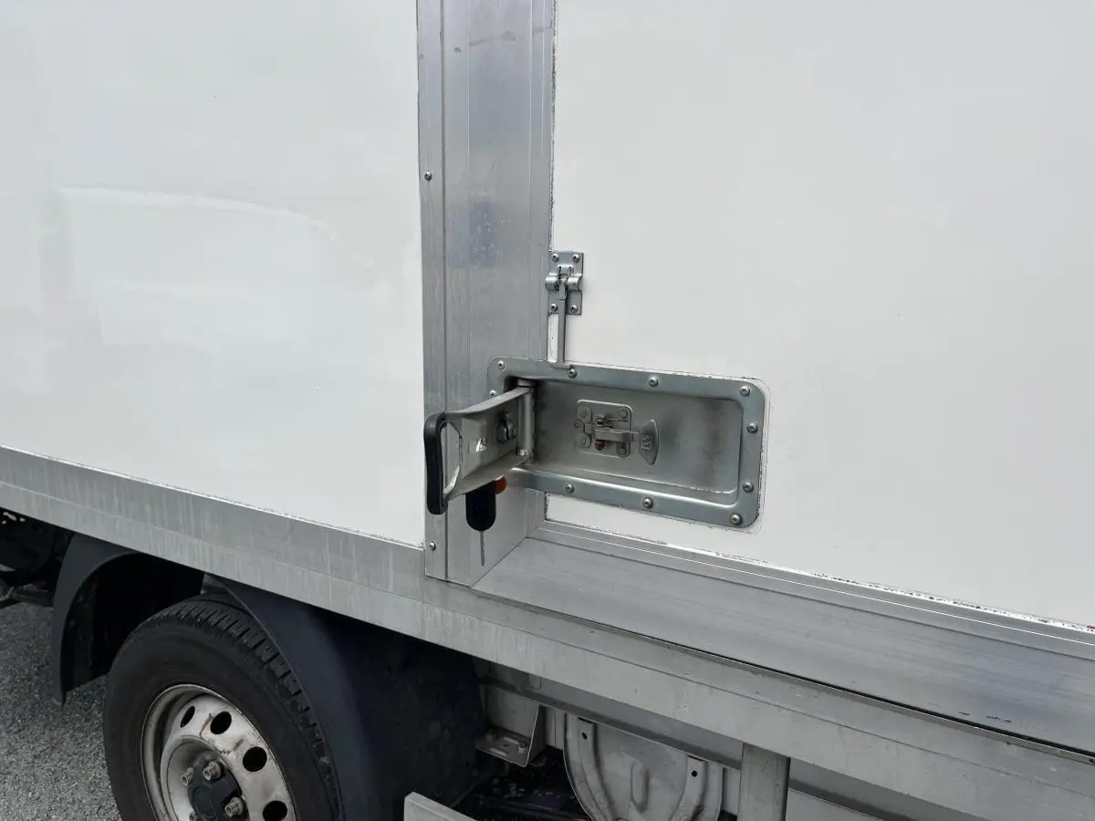 Détail de la poignée de porte latérale en métal sur la caisse blanche du FIAT Ducato Fourgon Maxi Business 2021.