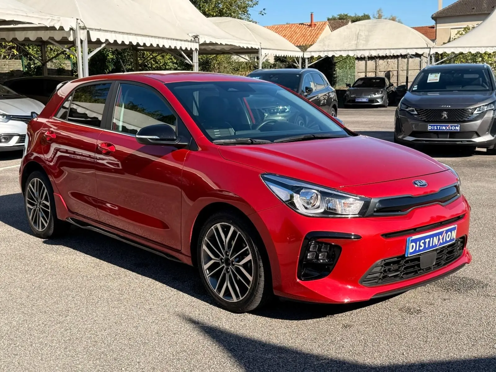 KIA RIO 1.0 T-GDI GT-LINE rouge grenadine vue 3/4 avant droit avec jantes alliage et calandre noire sportive.