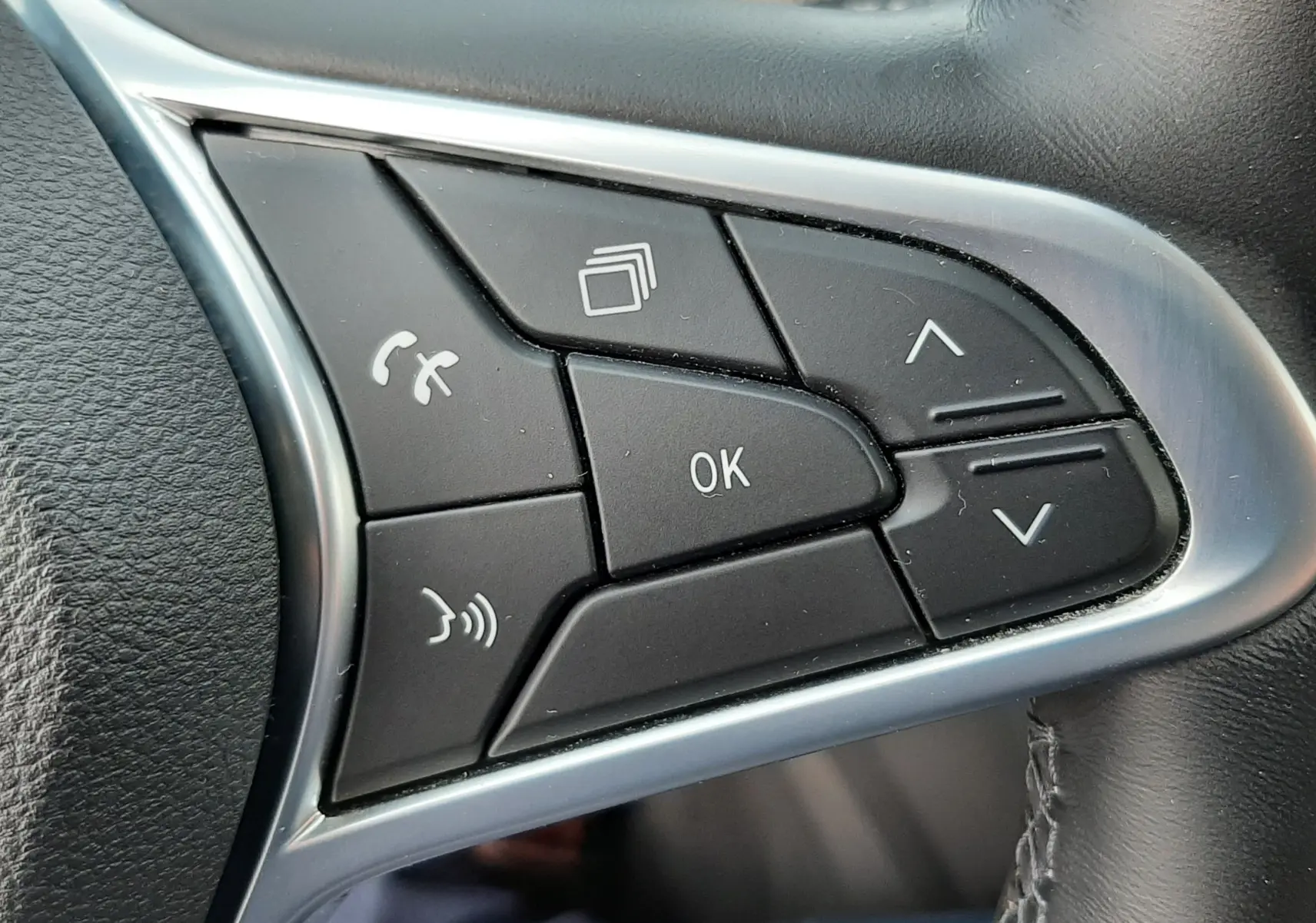 Gros plan sur les commandes noires du volant côté droit du Renault Arkana 1.6 E-TECH 145 Intens 2021.