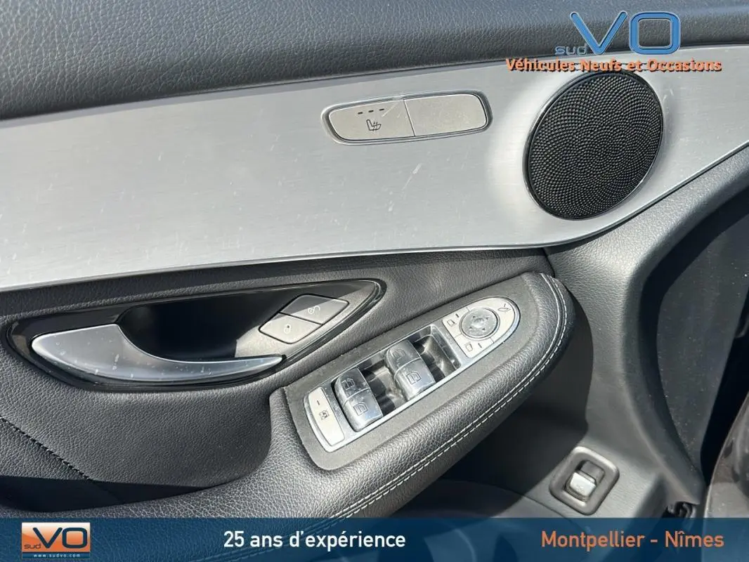 Gros plan sur la porte avant gauche du Mercedes GLC gris anthracite, avec commandes de vitres et haut-parleur intégré.