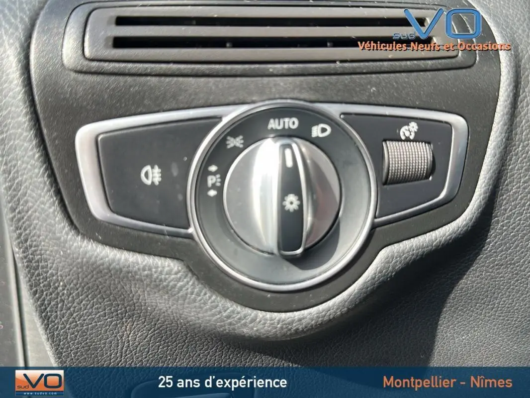 Gros plan sur le bouton de commande des phares dans l'habitacle d'un Mercedes GLC 300 de gris anthracite.