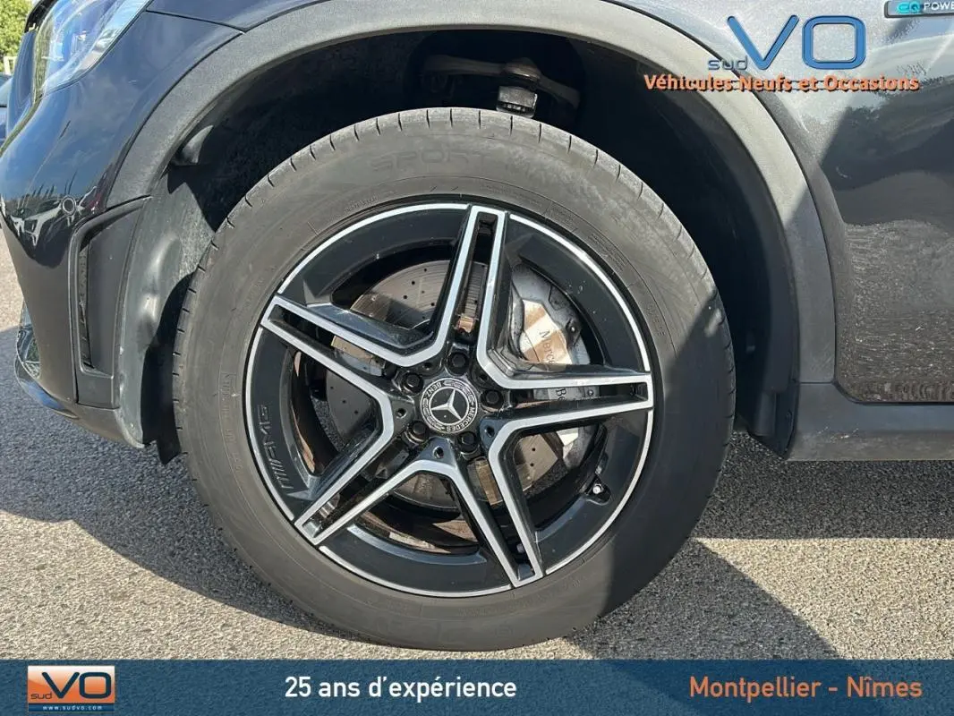 Gros plan sur la jante alliage noire à cinq branches du Mercedes GLC 300 de gris anthracite, version AMG Line.