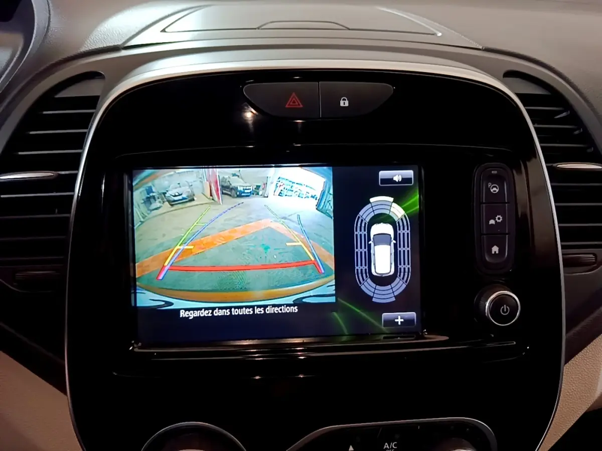 Écran tactile central affichant la caméra de recul et capteurs de stationnement du Renault Captur Intens orange.