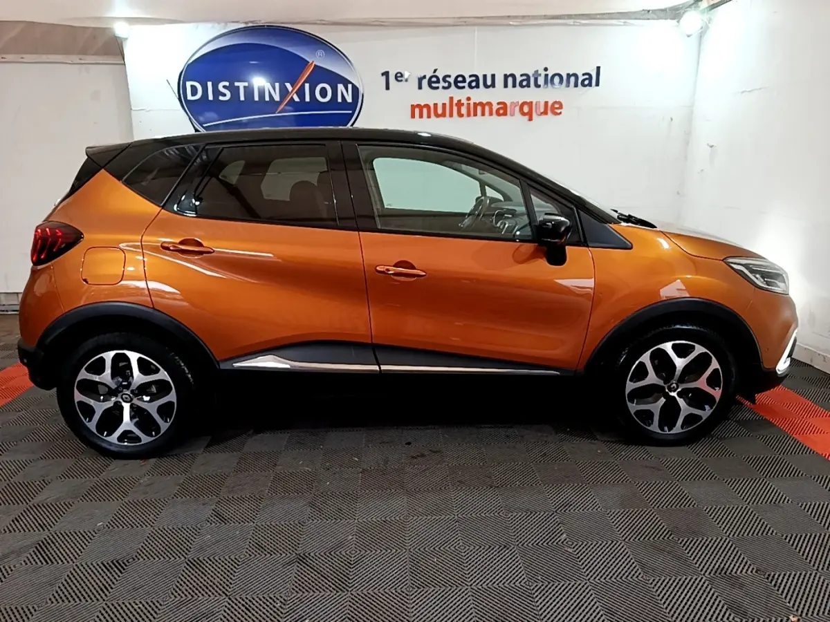 Profil côté gauche d'un Renault Captur Intens TCe 150 orange, avec toit noir et jantes alliage distinctives.