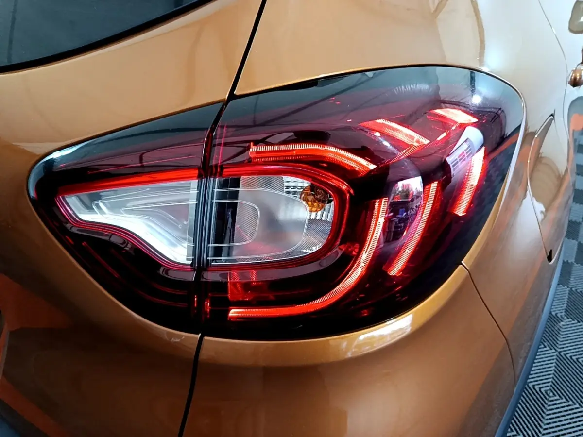 Gros plan sur le feu arrière droit rouge et blanc du Renault Captur Intens orange 2019, soulignant ses lignes LED distinctives.