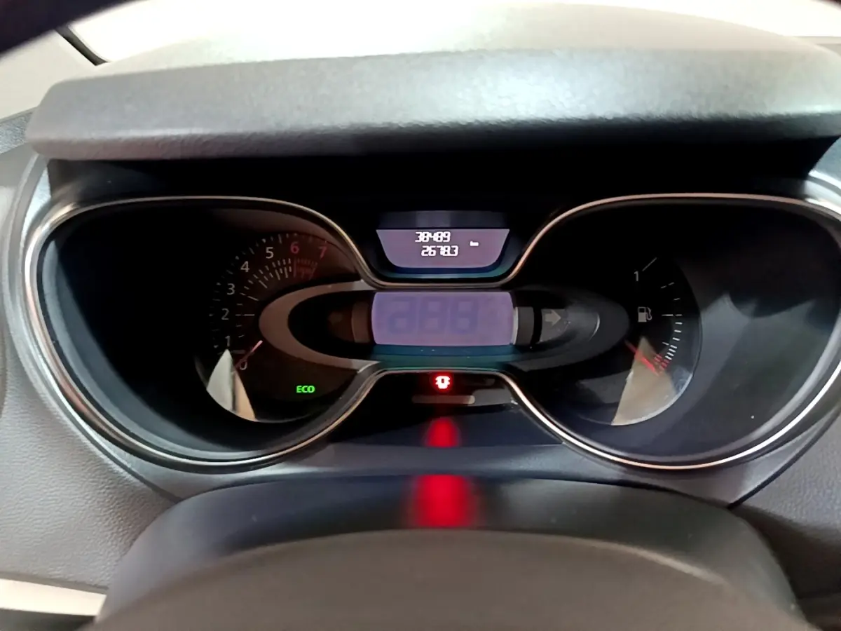 Vue rapprochée du tableau de bord numérique du Renault Captur Intens orange, affichant compteur et indicateurs lumineux.