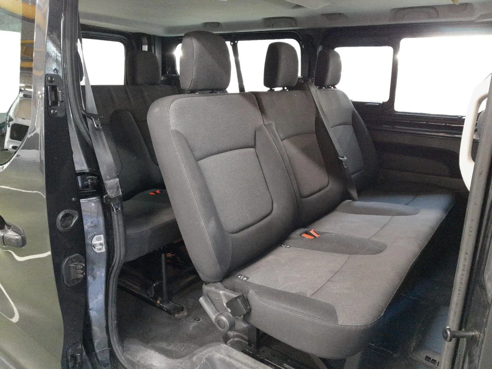 Vue intérieure côté droit du Renault Trafic Combi gris comète, montrant les sièges passagers en tissu gris.