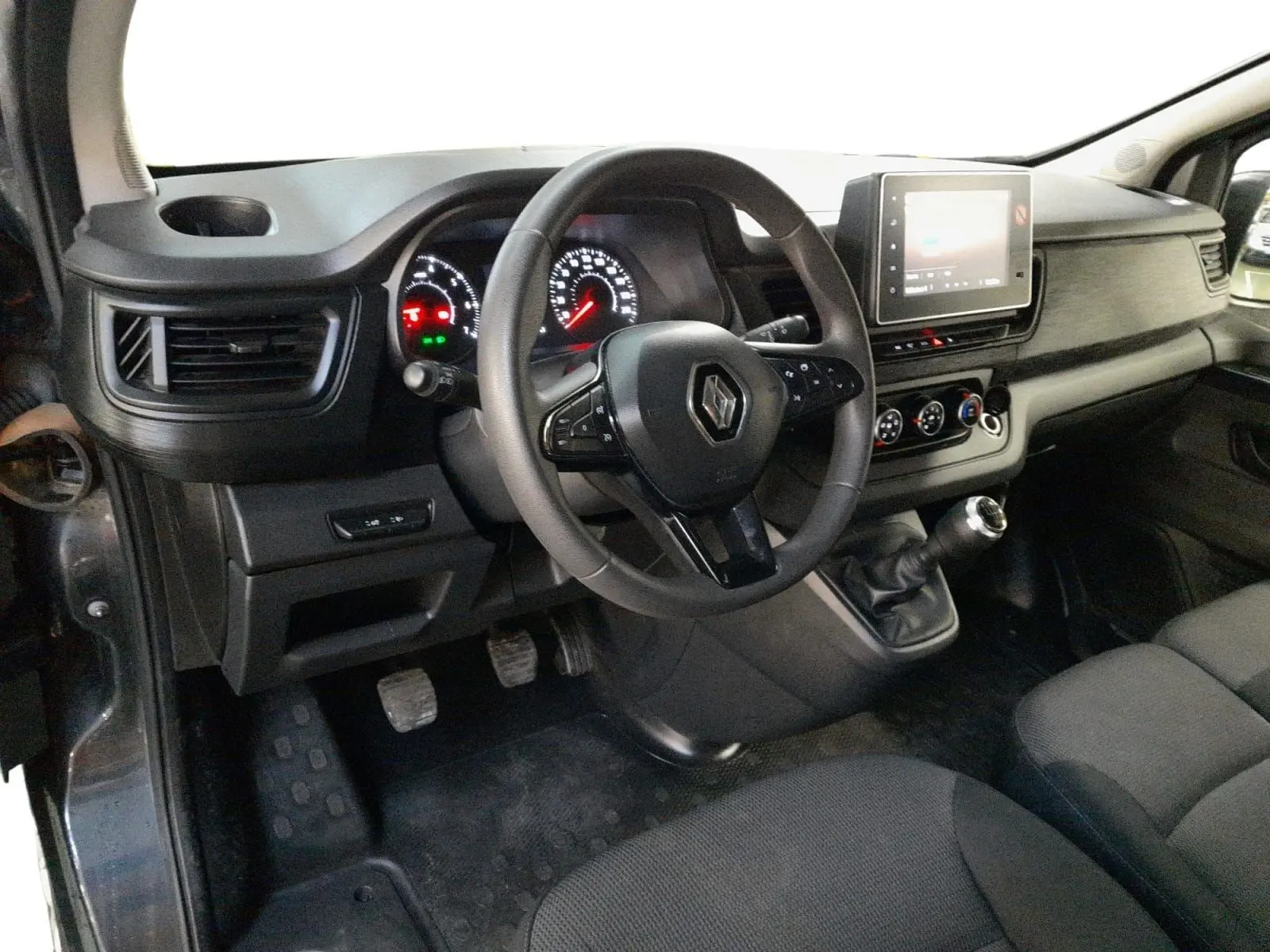 Vue intérieure côté conducteur du Renault Trafic Combi gris comète, avec volant multifonction et écran tactile 8 pouces.
