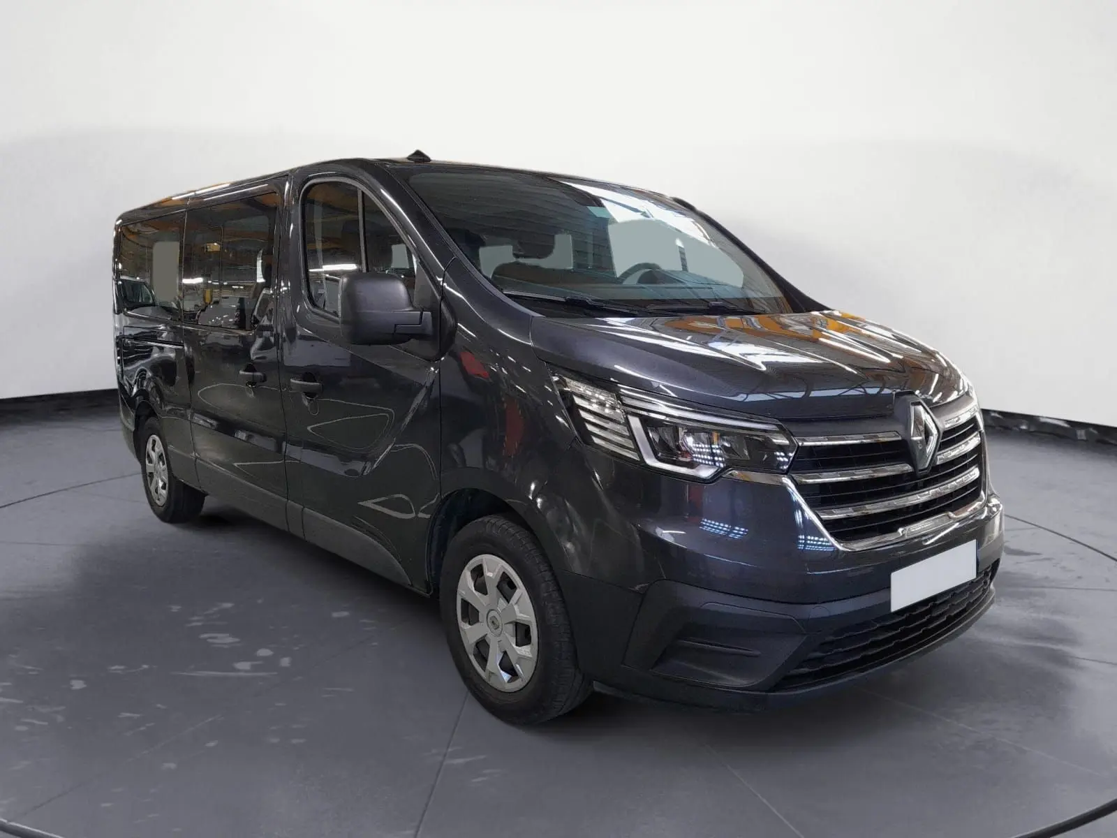 Renault Trafic Combi gris comète, vue 3/4 avant droit, mettant en valeur ses phares modernes et sa calandre chromée.