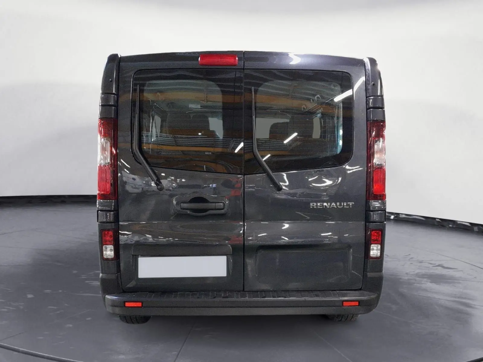Vue arrière du Renault Trafic Combi gris comète 2022 avec portes battantes et essuie-glaces arrière visibles.