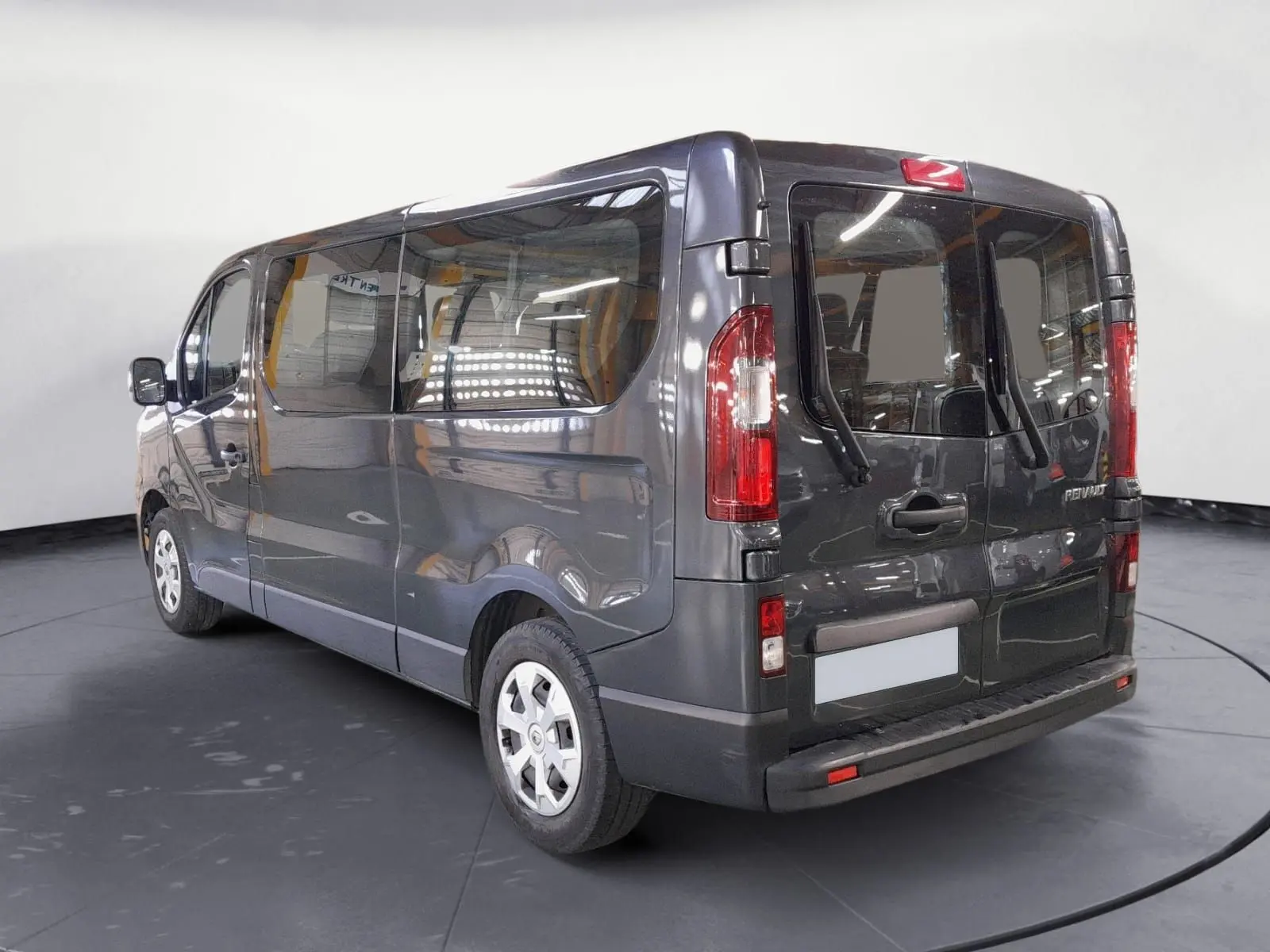 Renault Trafic Combi gris comète vu en 3/4 arrière droit, avec vitres latérales et portes arrière vitrées.