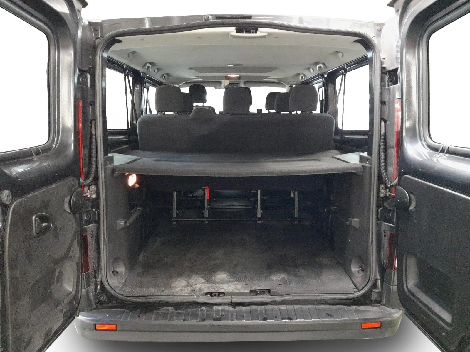 Vue arrière ouverte du Renault Trafic Combi gris comète, montrant l'espace de chargement et les sièges passagers à l'intérieur.