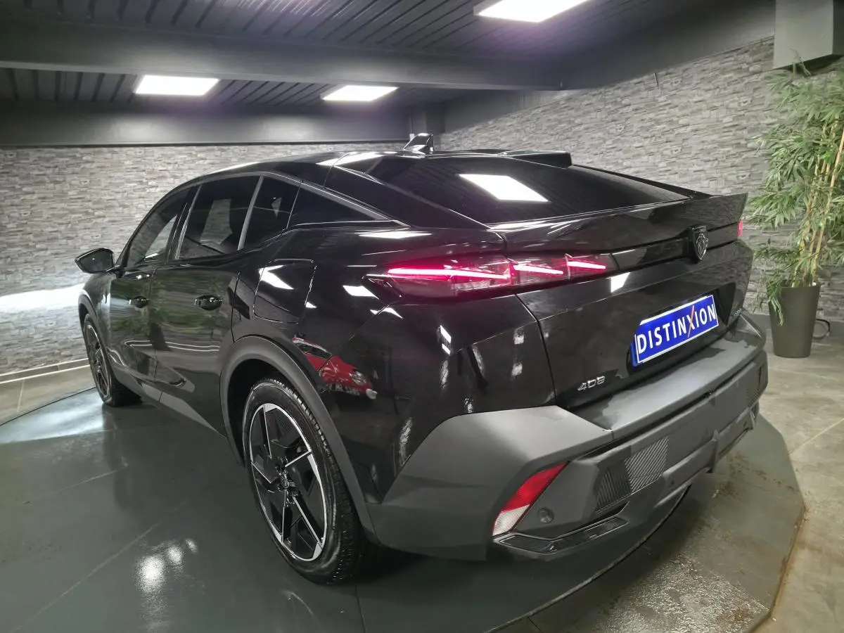 Vue 3/4 arrière droite d'une Peugeot 408 noire avec feux arrière LED dynamiques et jantes alliage 19 pouces.
