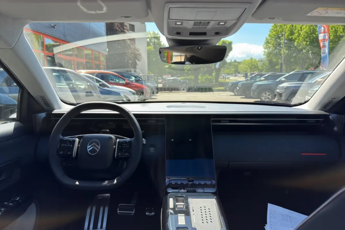 Vue intérieure avant du Citroën C5 Aircross 2026, tableau de bord noir avec grand écran tactile central et volant multifonctions.