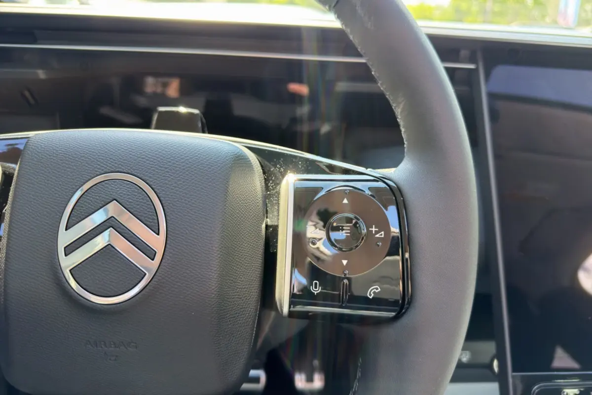 Gros plan sur le volant cuir multifonctions de la Citroën C5 Aircross New Hybrid 2026 avec commandes tactiles.