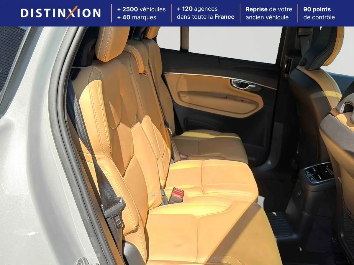 Vue intérieure côté gauche des sièges arrière en cuir beige du Volvo XC90 T8 hybride 2024 avec portières ouvertes.