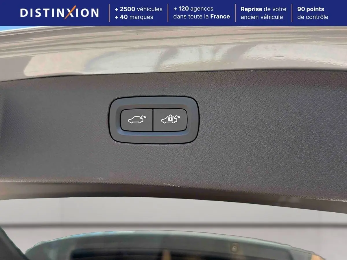 Boutons d'ouverture et de verrouillage électrique du hayon sur un Volvo XC90 gris, vue intérieure du coffre ouvert.