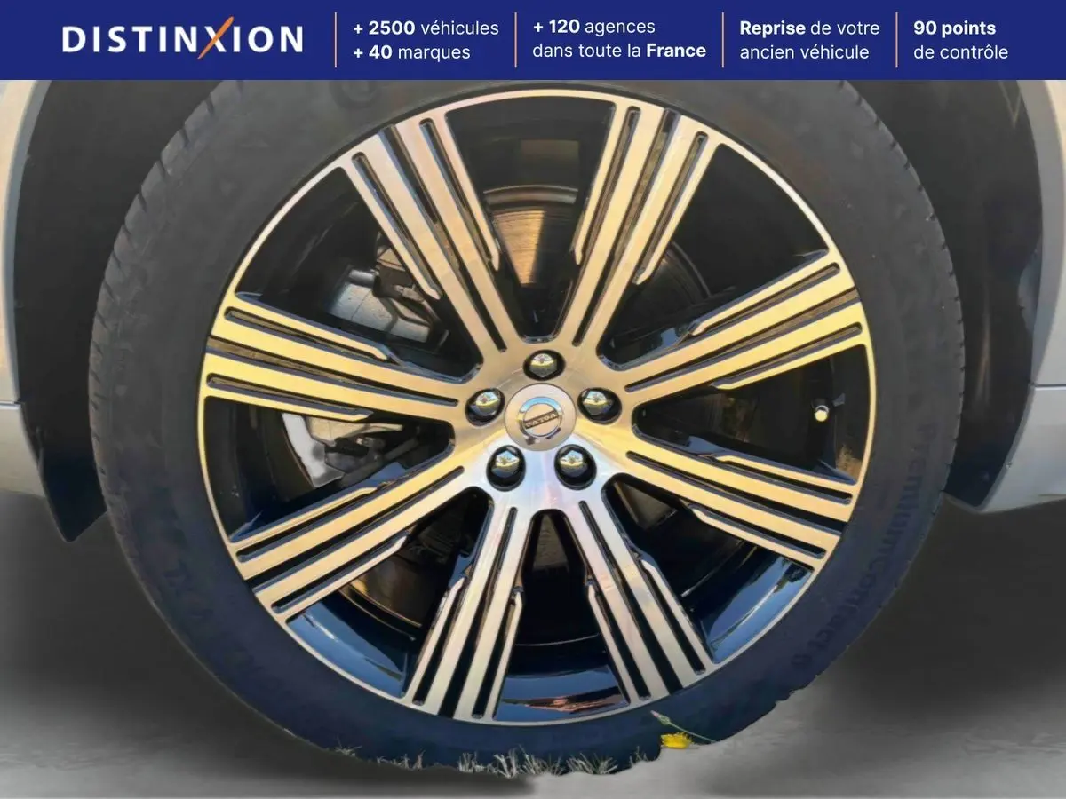 Gros plan sur la jante alliage 21 pouces noir et diamant du Volvo XC90 gris, avec logo Volvo au centre.