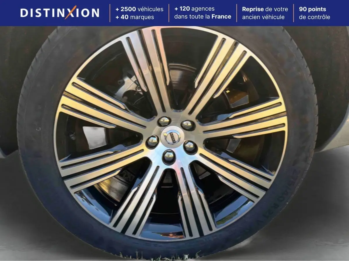 Gros plan sur la jante alliage 21 pouces noir et diamant du Volvo XC90 gris, mettant en valeur son design à 8 branches.