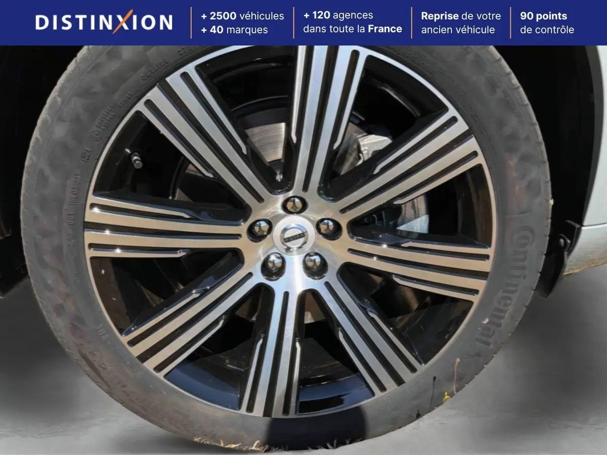 Gros plan sur la jante alliage 21 pouces noir et diamant du Volvo XC90 gris, avec pneu Continental visible.