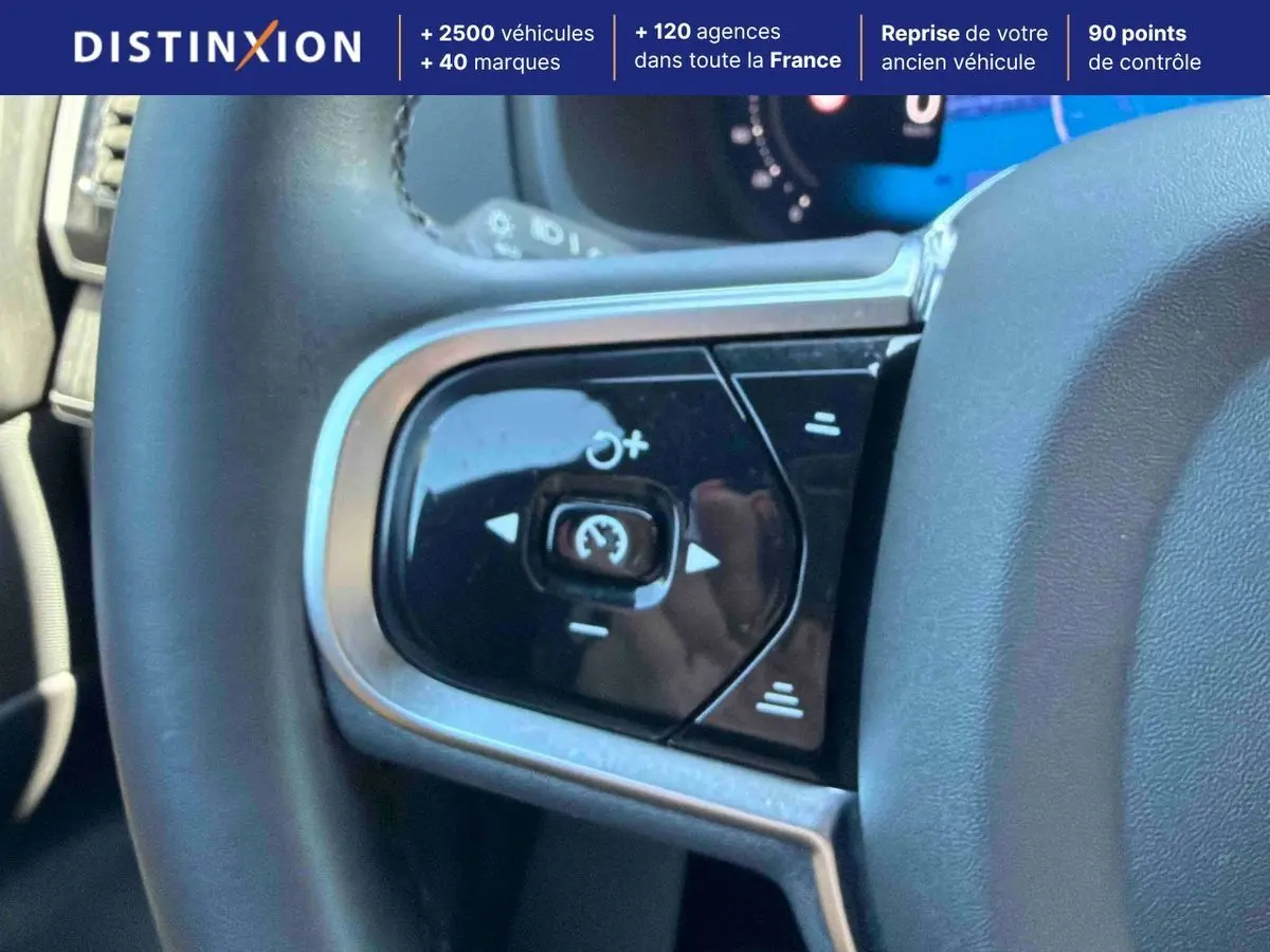 Gros plan sur les commandes du volant côté gauche d’un Volvo XC90 gris, avec régulateur de vitesse.