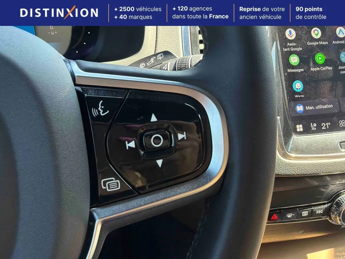 Gros plan sur les commandes au volant et l'écran tactile du tableau de bord du Volvo XC90 gris 2024.